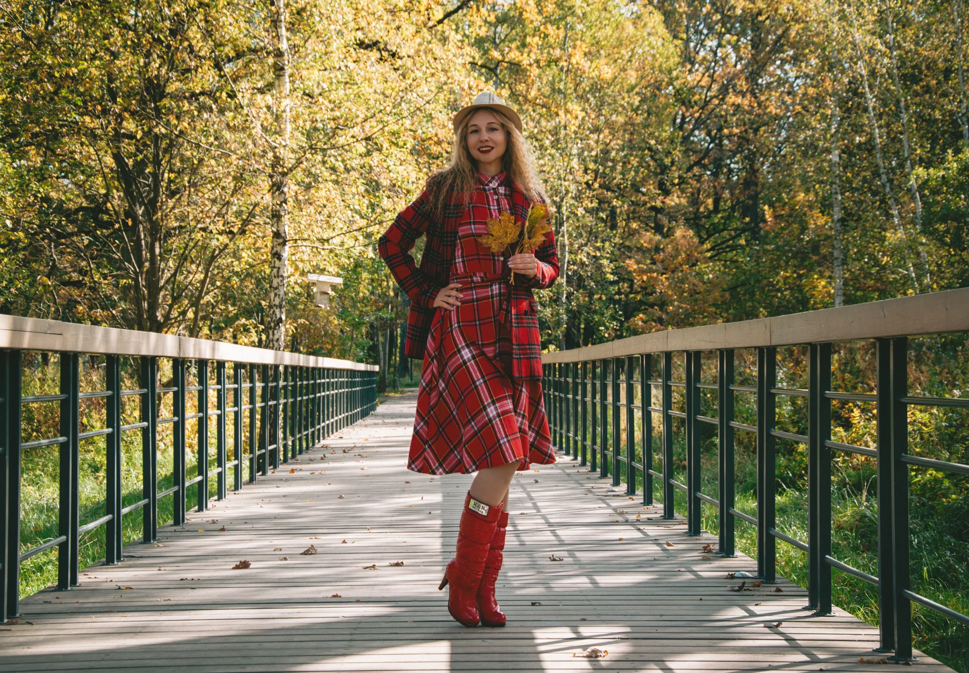 Stylowa kobieta spacerująca po jesiennym parku w eleganckim stroju, w sukience.